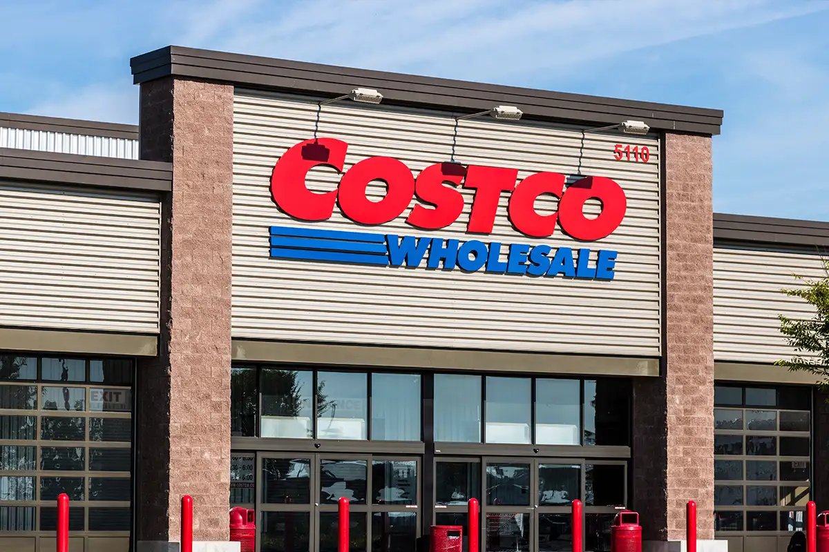 The front of a Costco Wholesale warehouse with its red and blue sign under a blue sky